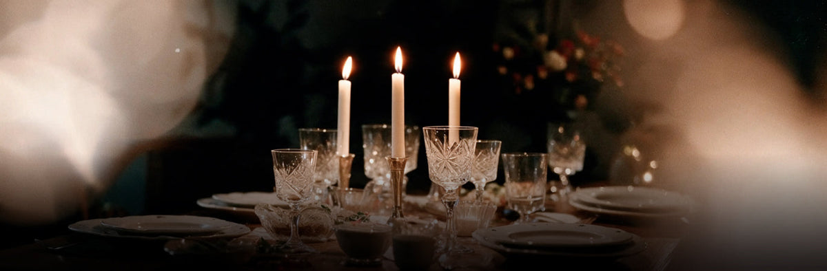 Amber menu photo of a candlelit table with crystal glasses and tall white tapers