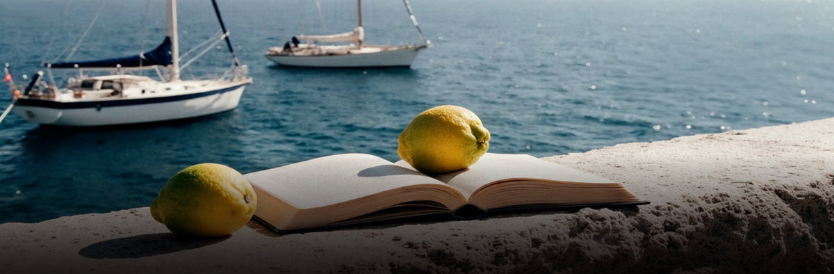 Fresh menu photo of lemons and an open book on a stone ledge by two sailboats