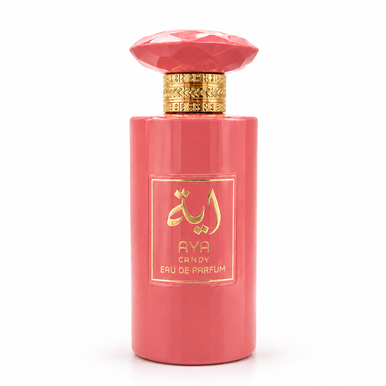 AYA CANDY Eau de Parfum cylindrical bright coral pink opaque bottle topped with a matching faceted gem-shaped cap and ornate gold collar, featuring a square gold-framed label with gold Arabic calligraphy.