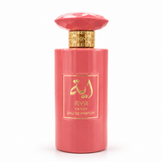 AYA CANDY Eau de Parfum cylindrical bright coral pink opaque bottle topped with a matching faceted gem-shaped cap and ornate gold collar, featuring a square gold-framed label with gold Arabic calligraphy.