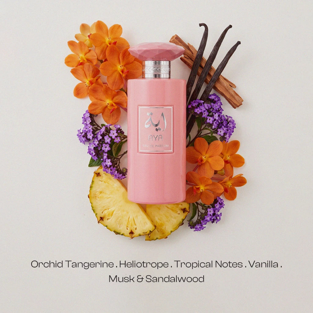 Woman in a white satin robe holding the pink AYA Eau de Parfum bottle and spraying a fine fragrance mist onto her neck, holding the faceted gem cap in her other hand.