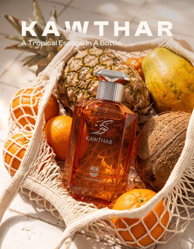 KAWTHAR Eau de Parfum by MUSHMUSH, an affordable luxury tropical perfume , resting in a woven net bag filled with fresh oranges, papaya, pineapple, and coconut.
