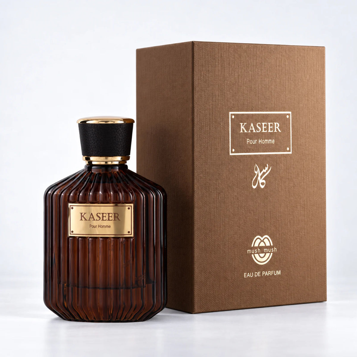 Kaseer Pour Homme amber perfume bottle beside its brown presentation box by MUSHMUSH