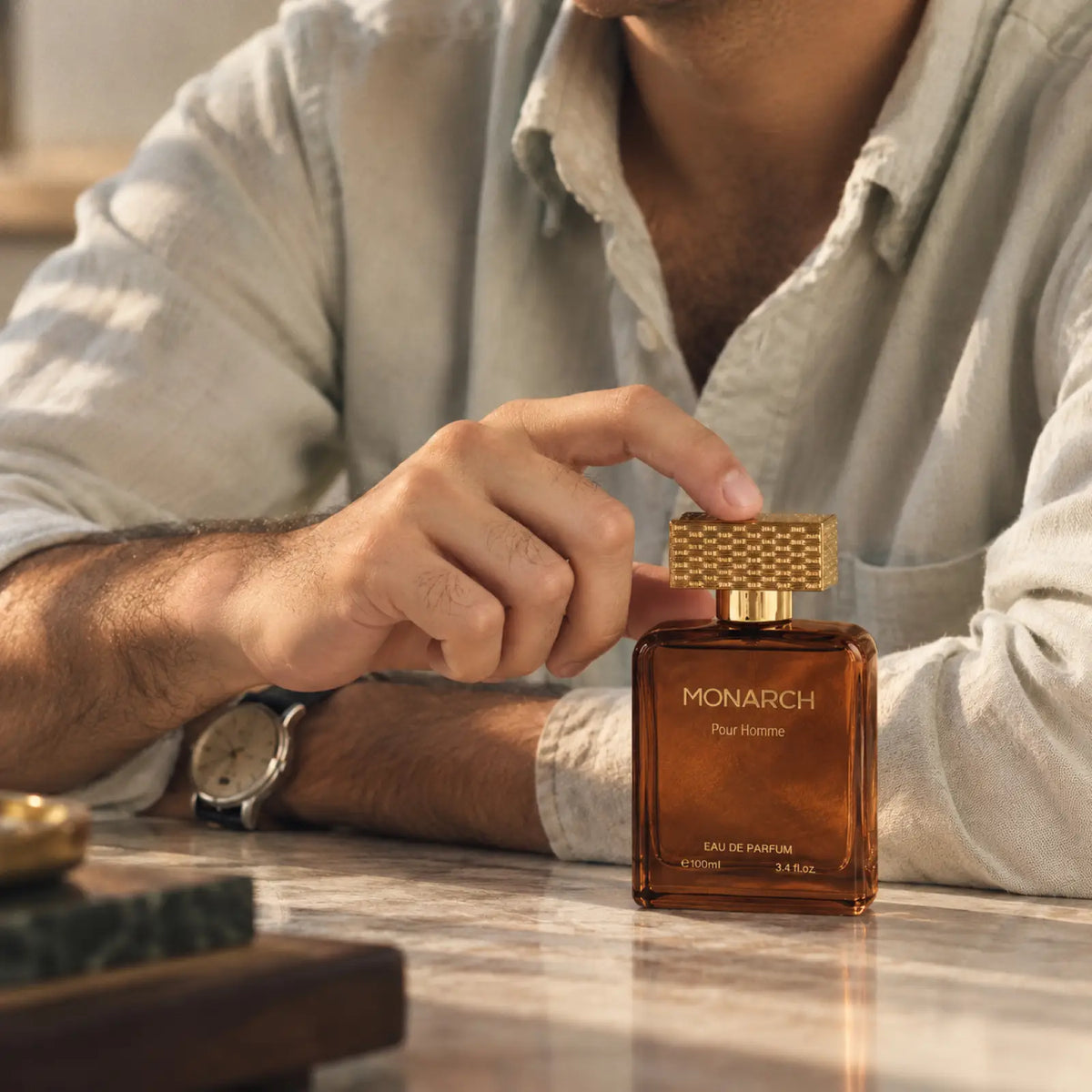 Monarch perfume for men and women shown with a person holding the bottle.