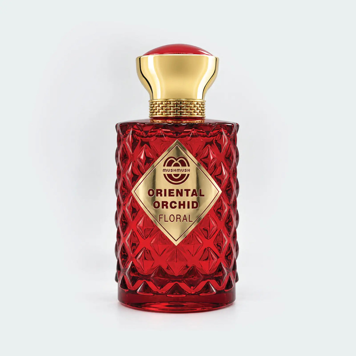 Oriental Orchid Floral ruby red Eau de Parfum bottle with a metallic gold cap and gold diamond-shaped label by MUSHMUSH