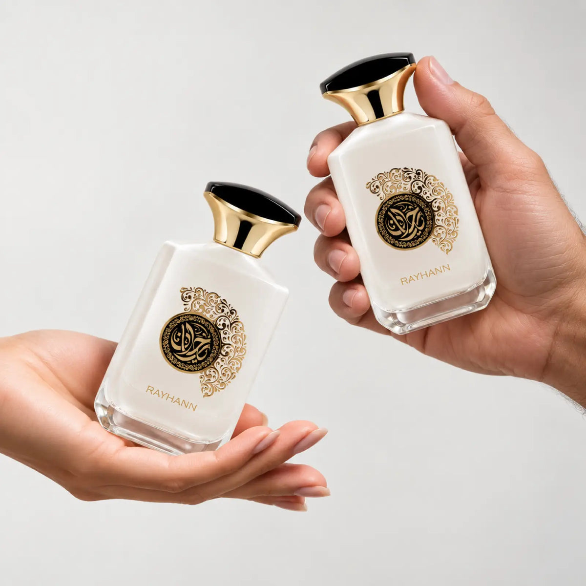 Rayhann for men and women perfume bottle passed between two hands