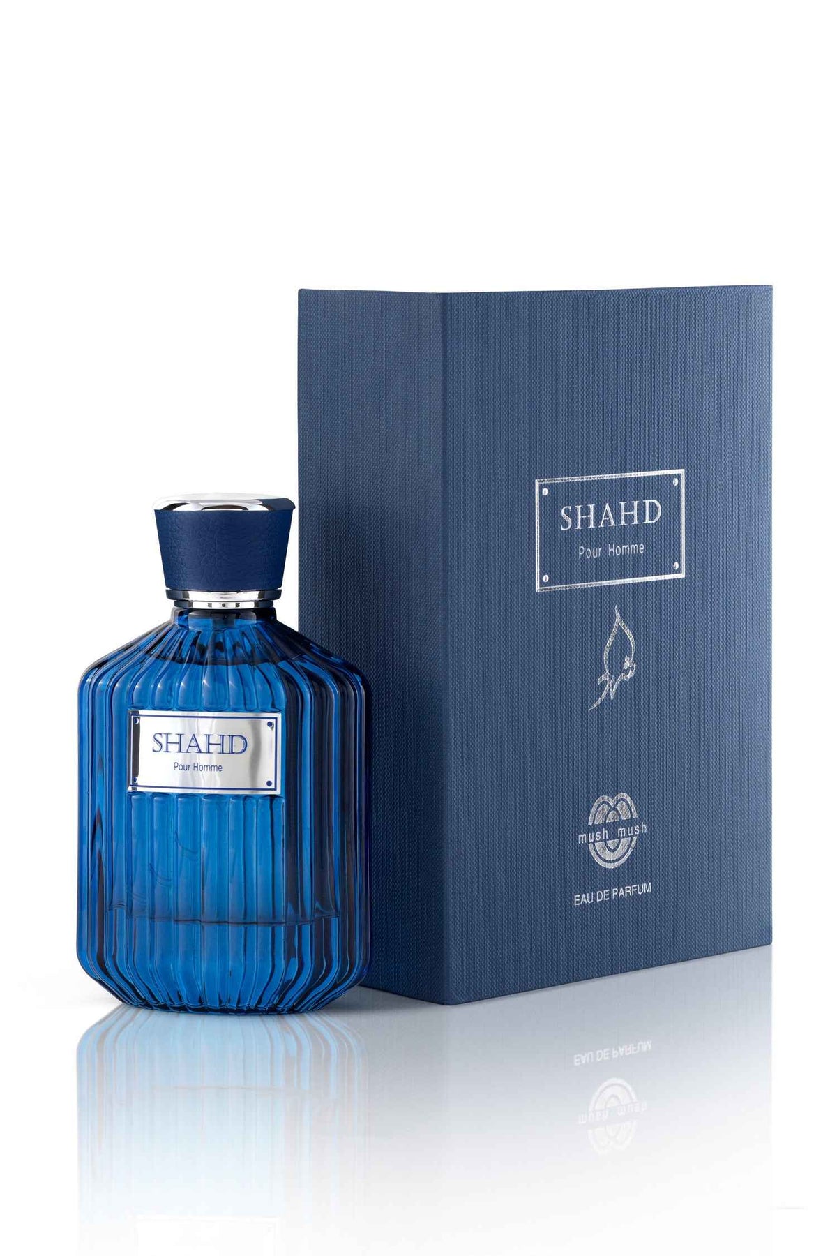 SHAHD Pour Homme Eau de Parfum ribbed deep cobalt blue glass bottle standing next to its matching textured navy blue presentation box featuring silver foil typography and branding accents.